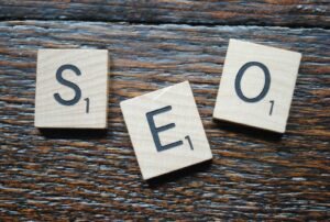 Gros plan des tuiles de Scrabble orthographiant SEO sur une table en bois pour la stratégie de contenu.
