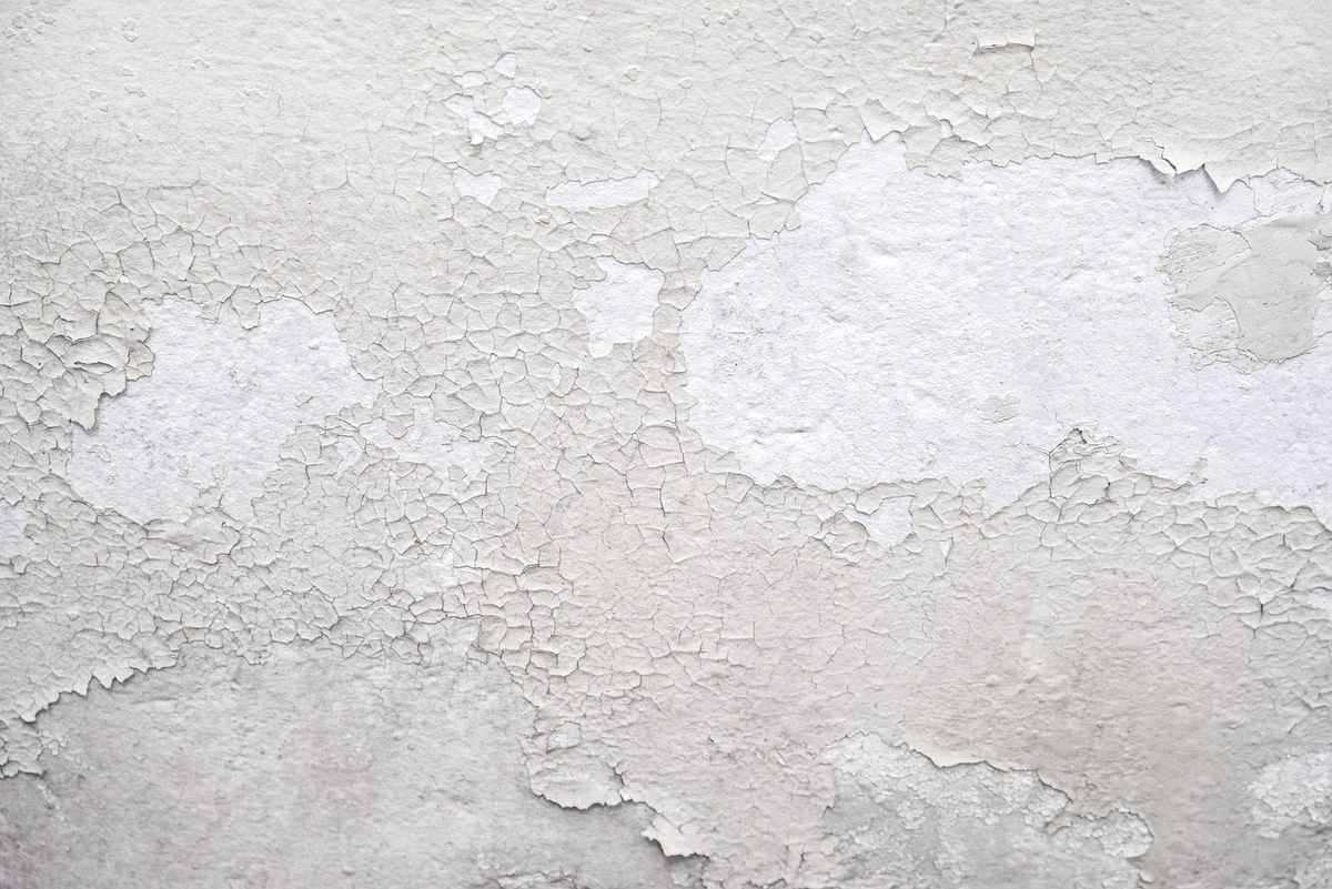 Peinture blanche qui s'écaille sur un mur texturé