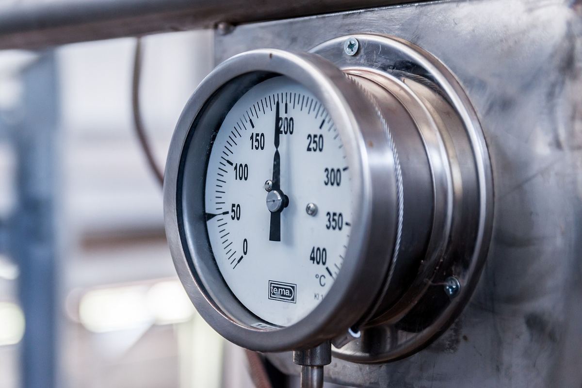Gauge métallique fixée à un tuyau, affichant une température de 200 degrés