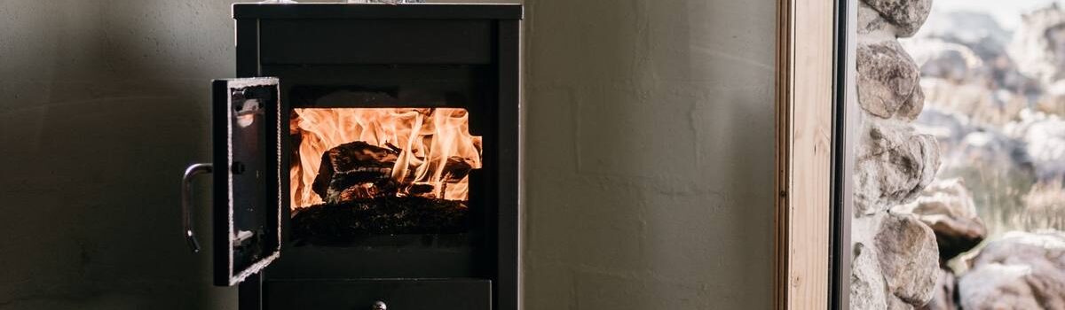 Un poêle à bois en fonctionnement avec un verre de vin posé dessus
